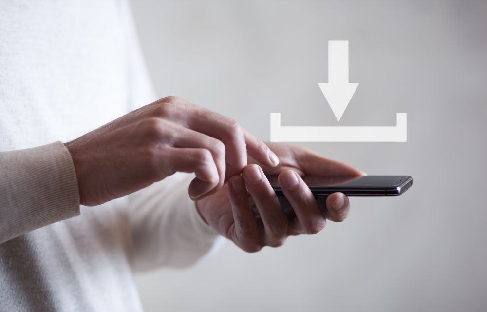 Download concept above a smartphone held by a man